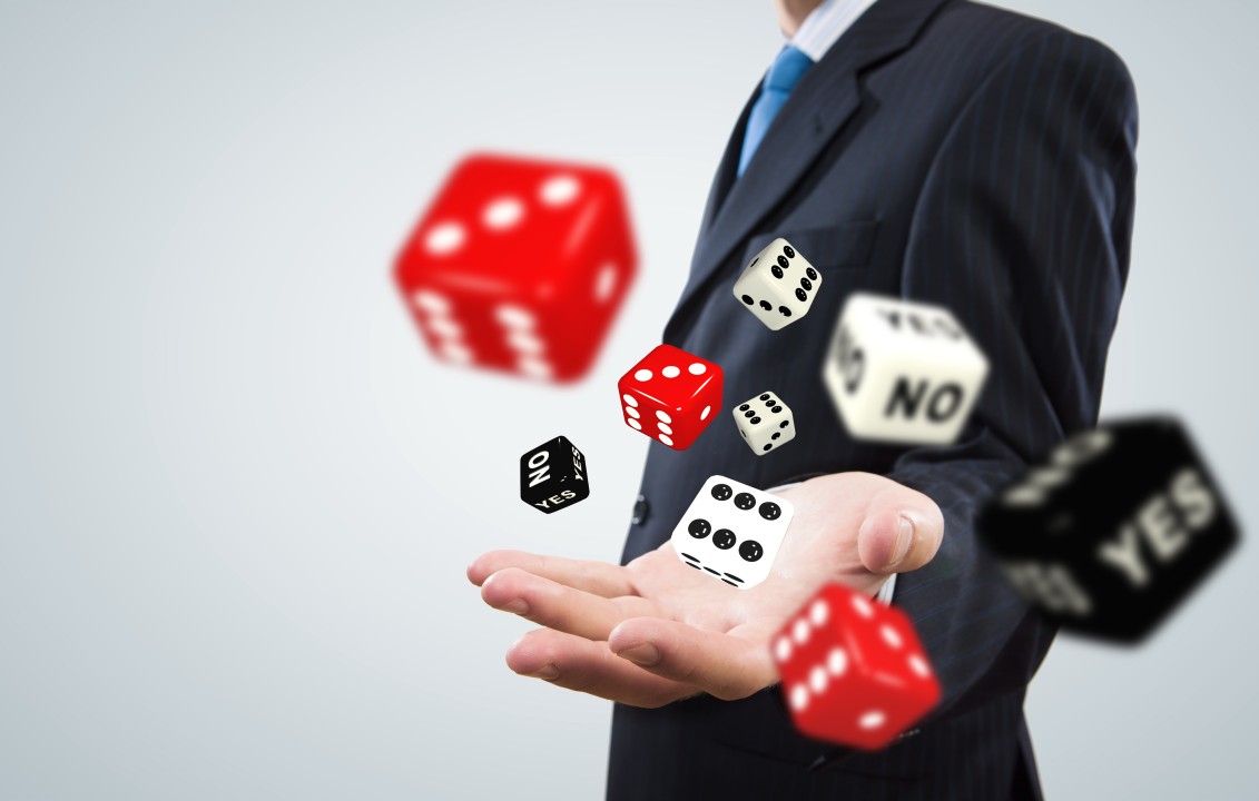 An ambiguous figure in a suit throwing dice towards he camera.