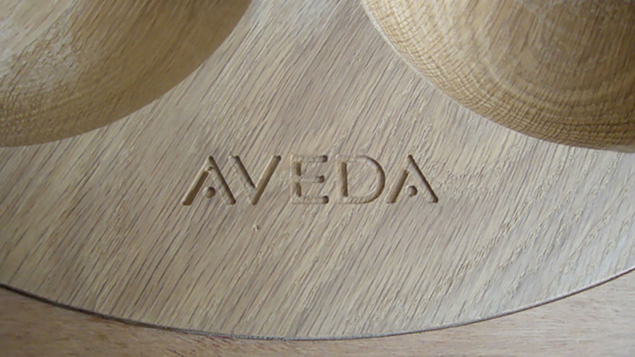The Aveda company logo routed in to a wooden bowl.