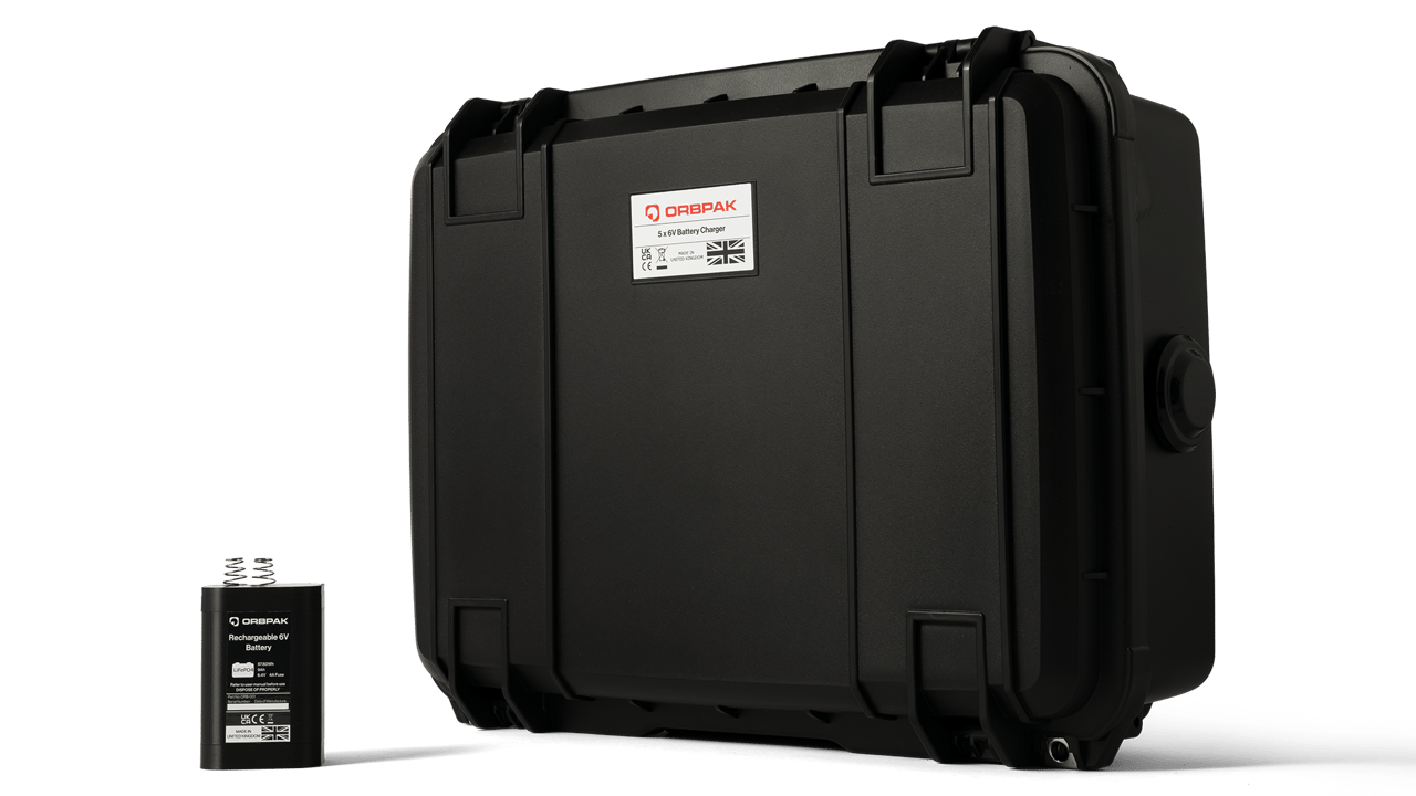 An ORBPAK battery standing next to its charging case.