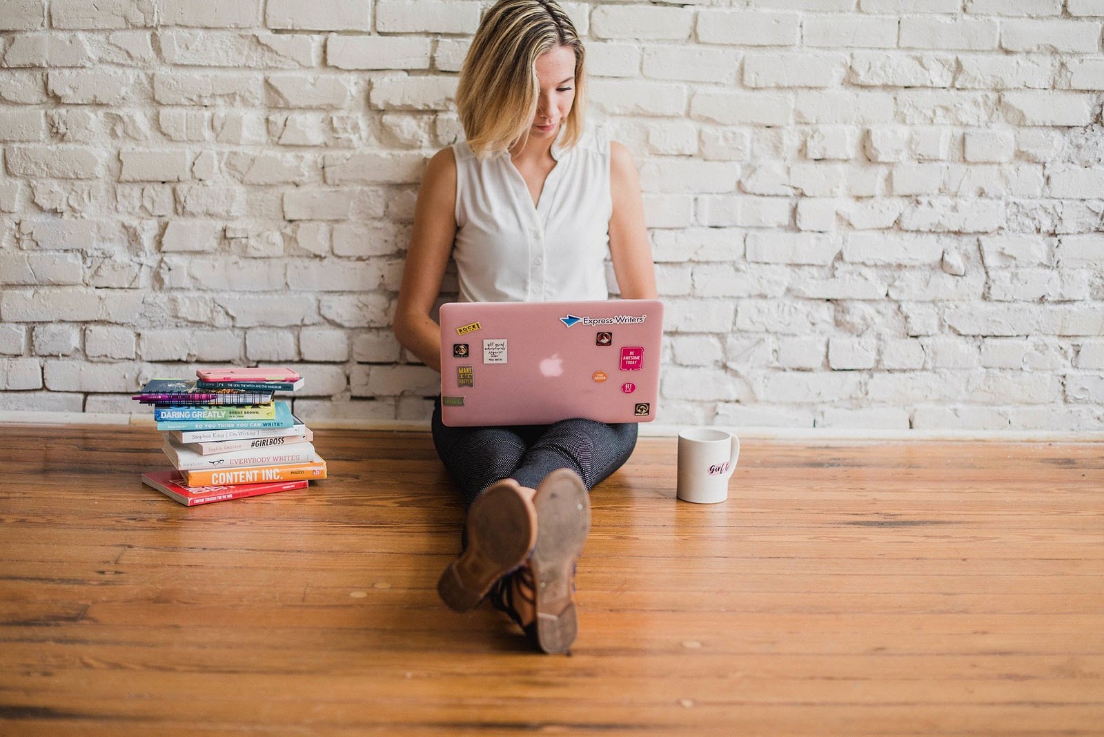A woman sat on the floor with her laptop.