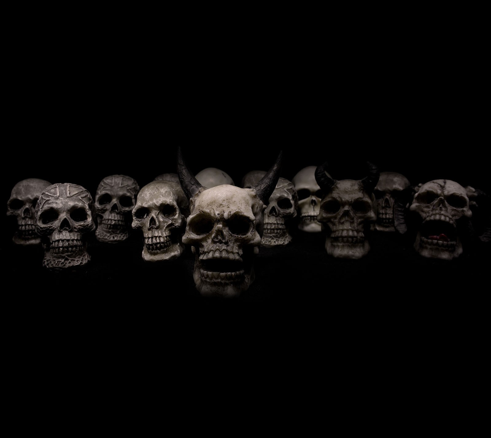 A scary looking row of skulls on a black background.