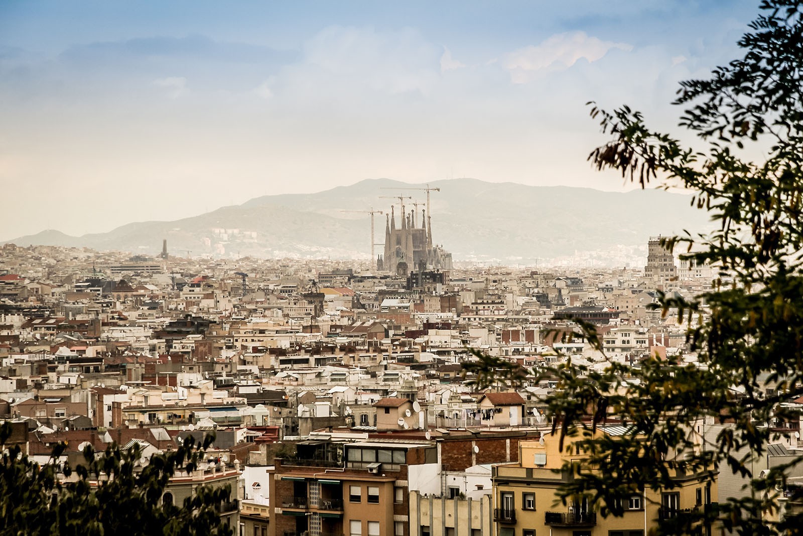 The city of Barcelona from afar. The prominent and recognisable landmark La Sagrada Familia towers above the city.