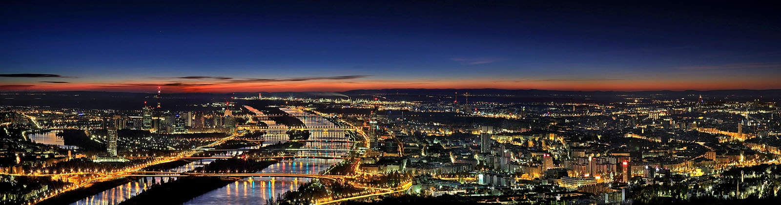 An aerial view of the Danube through Vienna at dusk.