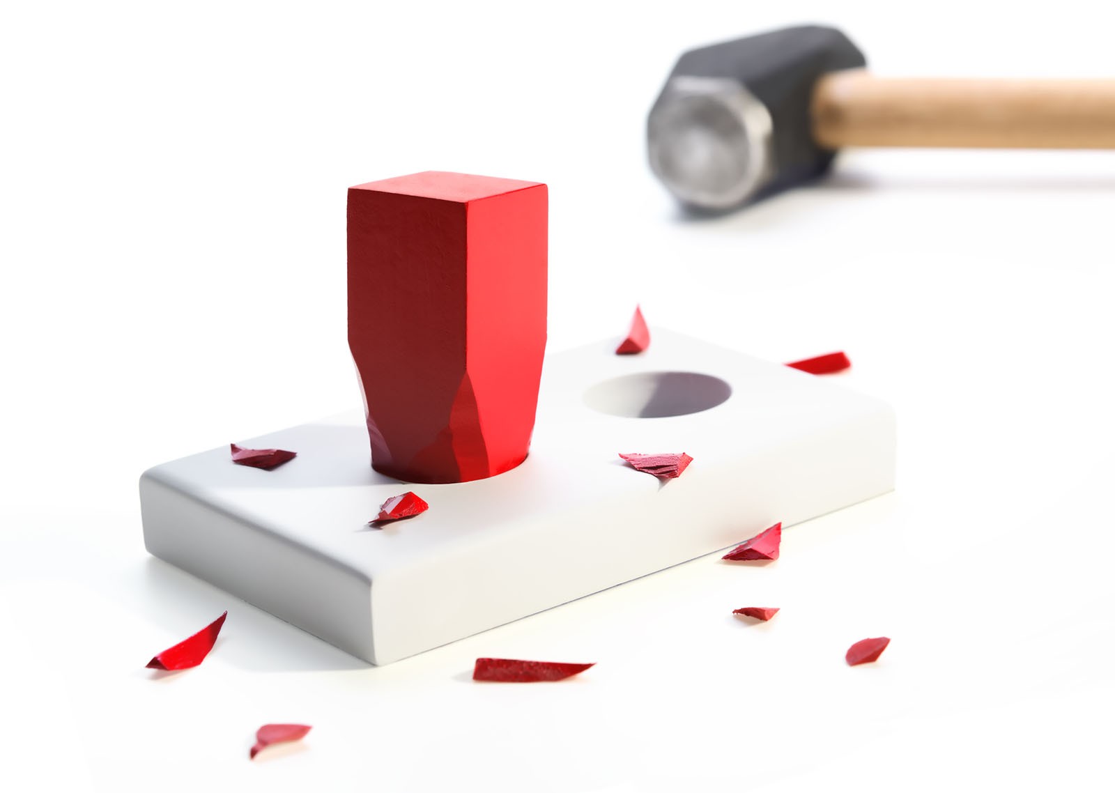 A square peg smashed in to a round hole with a hammer.