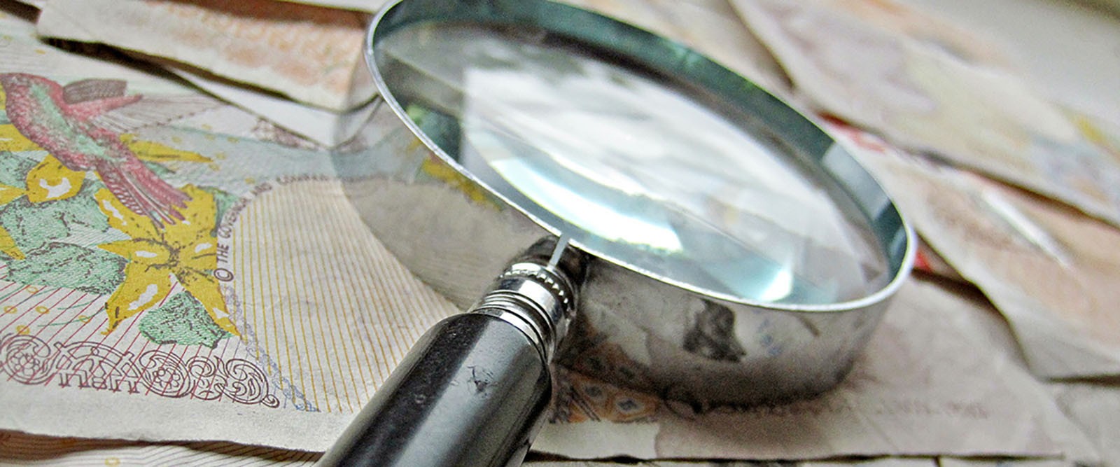 A magnifying glass laid on top of some money.