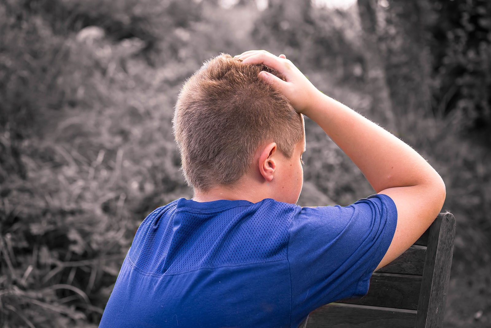A young boy with blond hair stressing over his tablet.