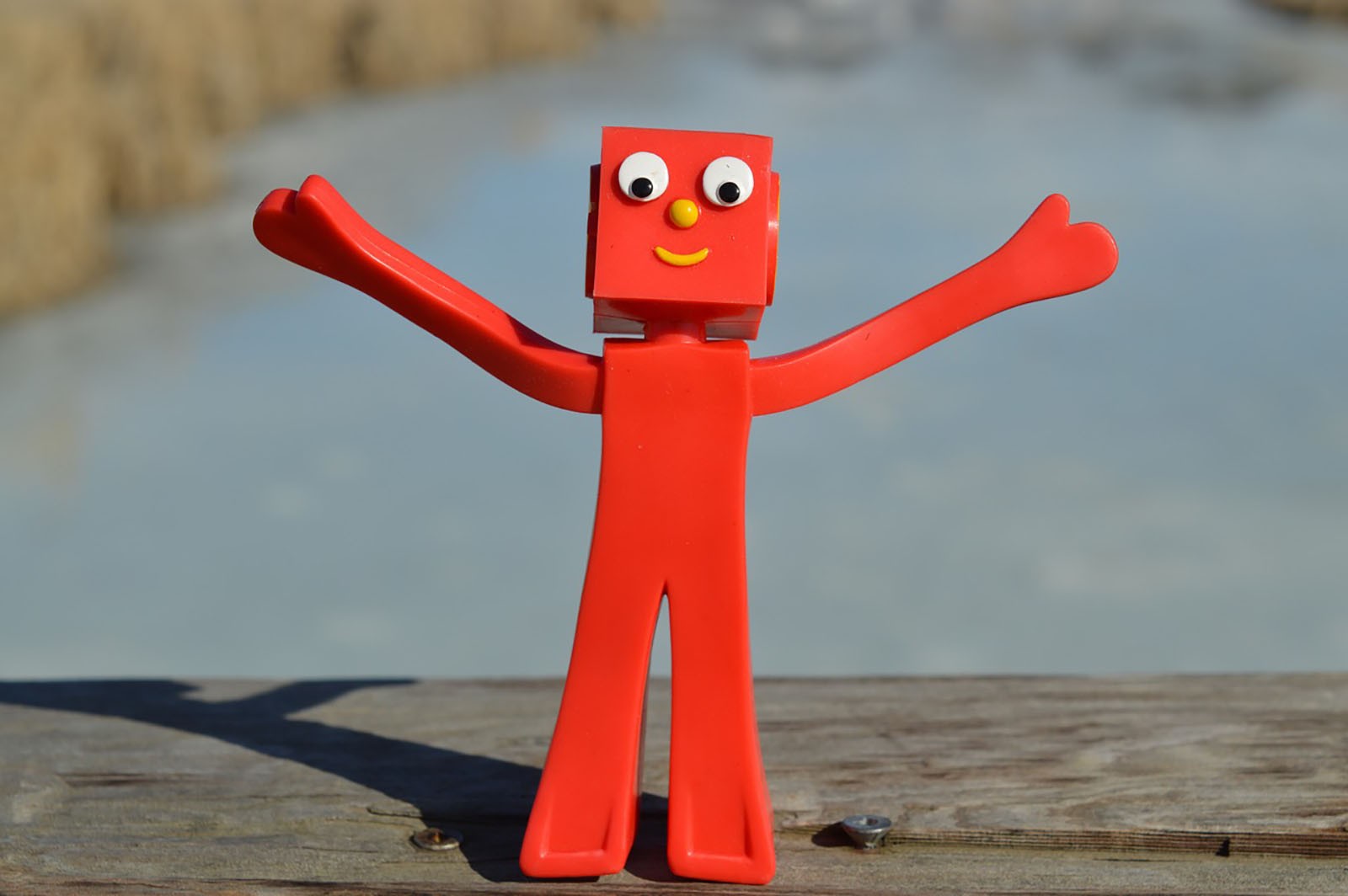 A red robot celebrating with it’s arms in the air.