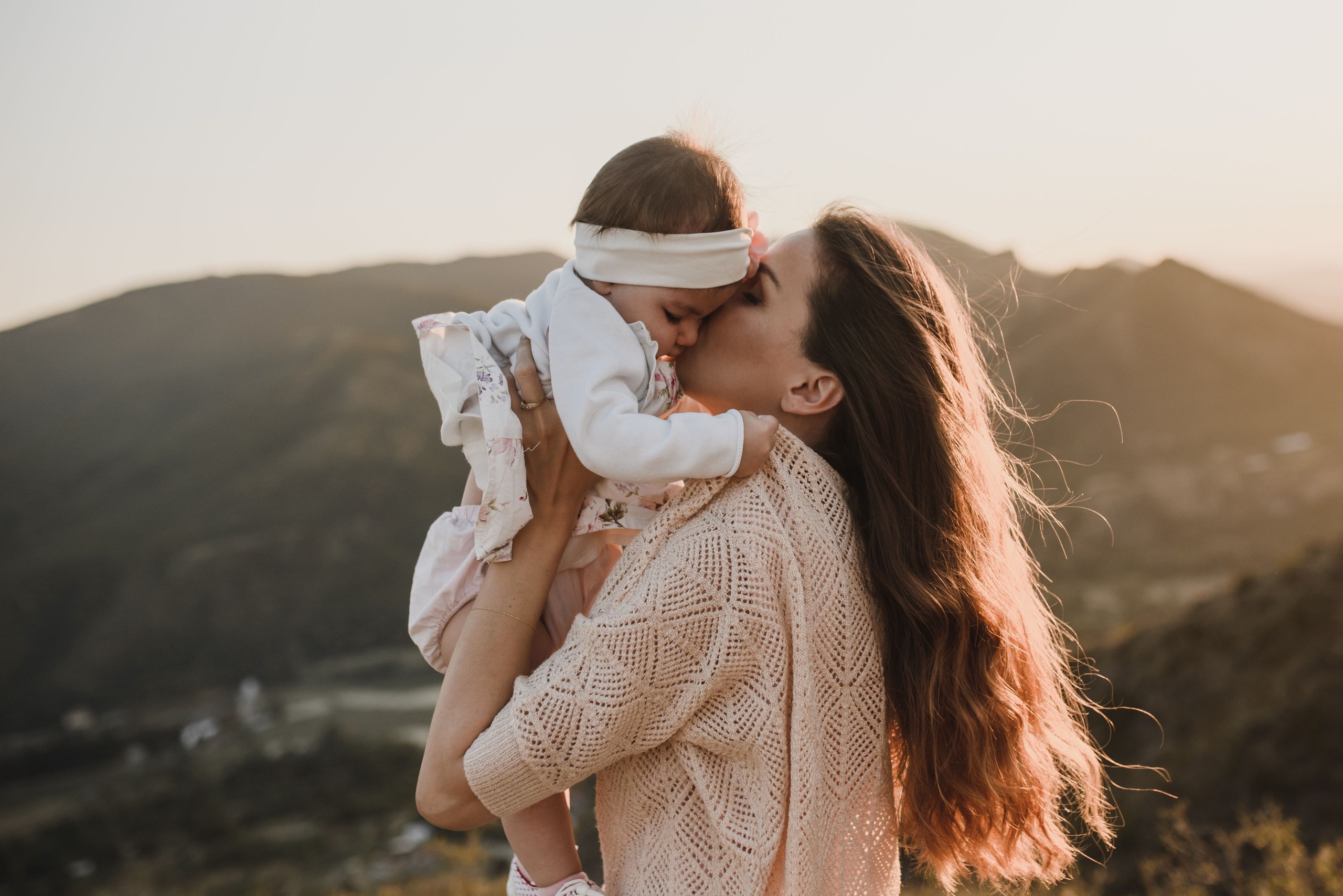 A mother and her baby outside on a warm sunny day.